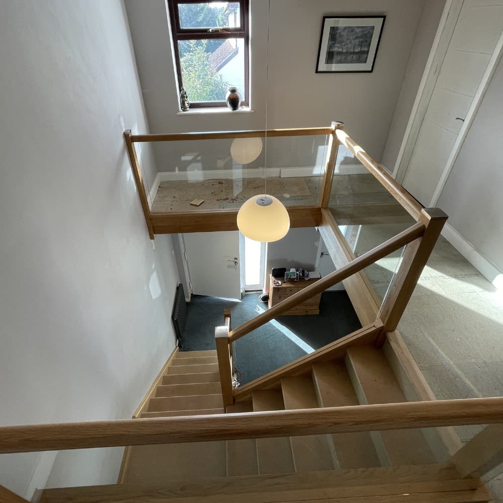 Wooden staircase paired with glass balustrade panels